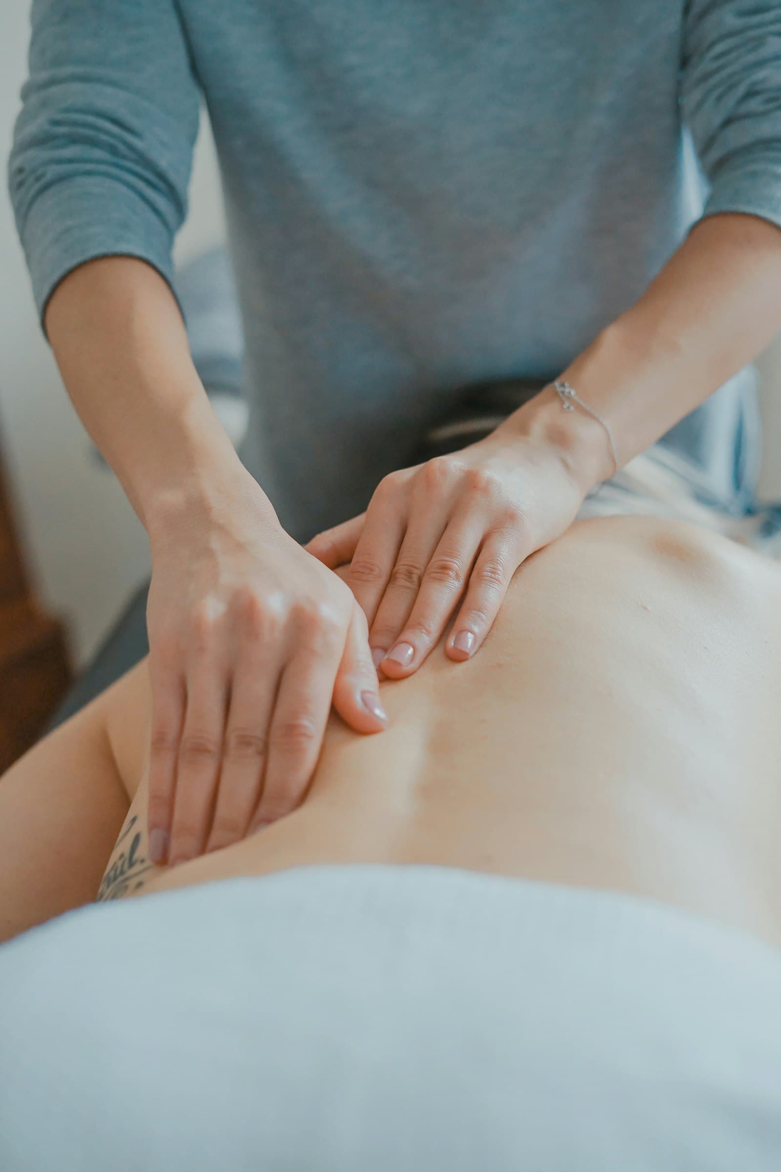A physical therapist providing hands-on care during an in-home visit